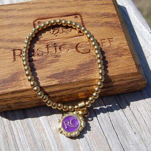 Rustic Cuff Ireland gold bracelet with purple RC logo charm